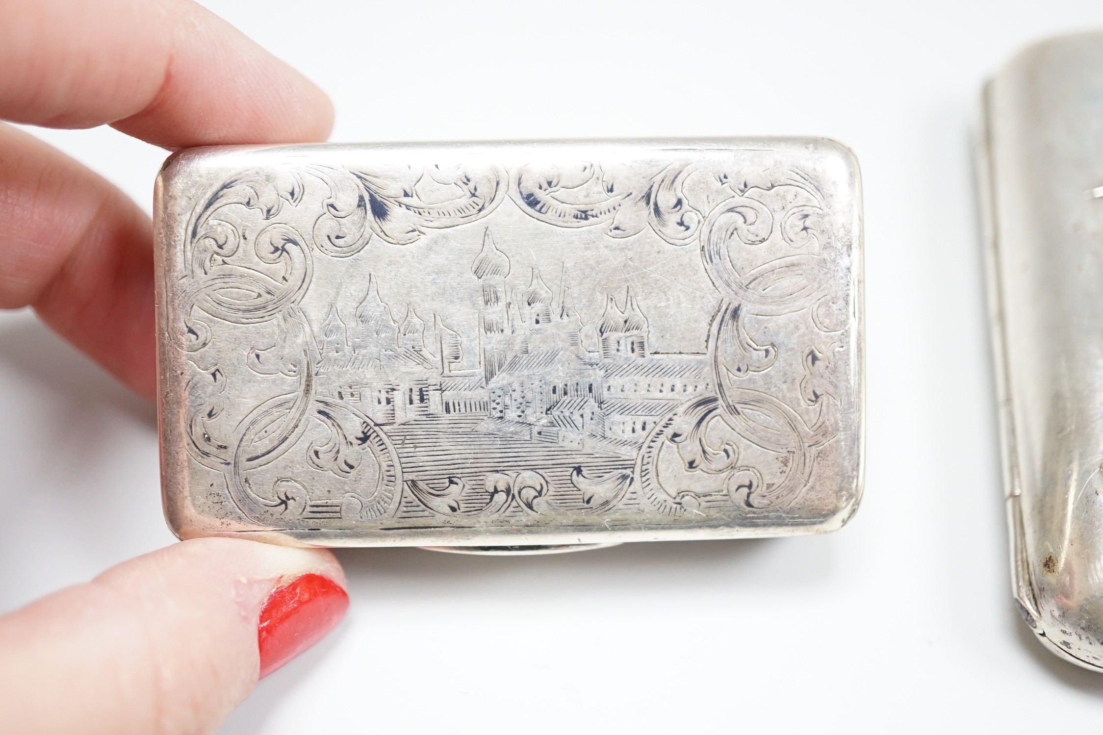 A white metal cigarette case, with applied dragon, 82mm, one other silver cigarette case and a Russian 84 zolotnik snuff box(tired).